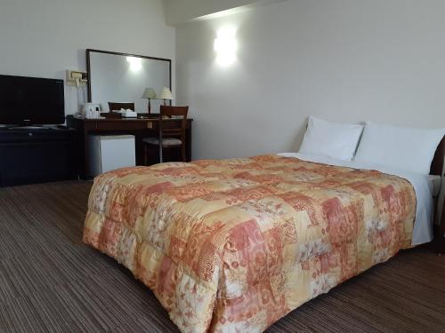 a hotel room with a bed and a desk at Hotel New Plaza Kurume in Kurume