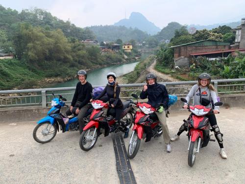 a group of people riding motorcycles on a bridge at Be's Home & Tours in Ha Giang