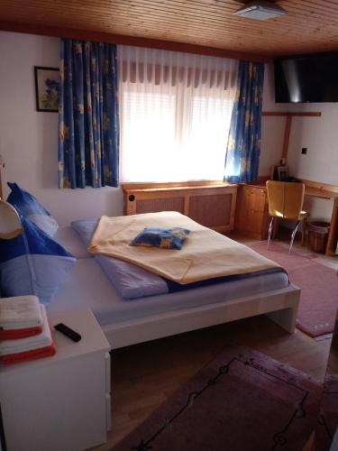 a bedroom with a bed and a window and a table at Gasthof Pisl in Krumpendorf am Wörthersee