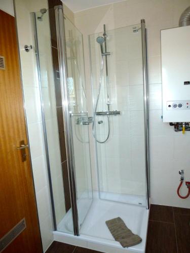 a shower with a glass door in a bathroom at Ferienwohnung Besslich Wattweg 5 in Norden