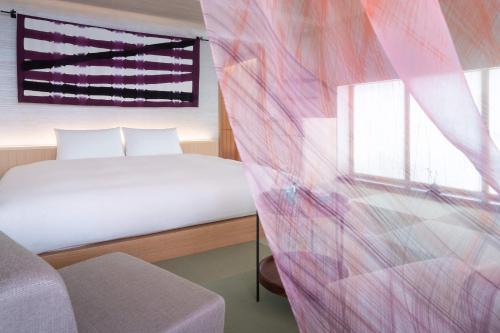 a bedroom with a bed and a window at THE JUNEI HOTEL Kyoto in Kyoto