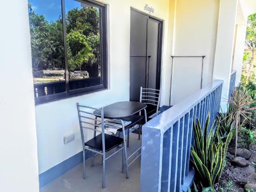 a balcony with two chairs and a window at Adayo Cove Resort in Siquijor