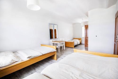 Habitación con 2 camas y mesa. en Zielona Przystań, en Manasterz