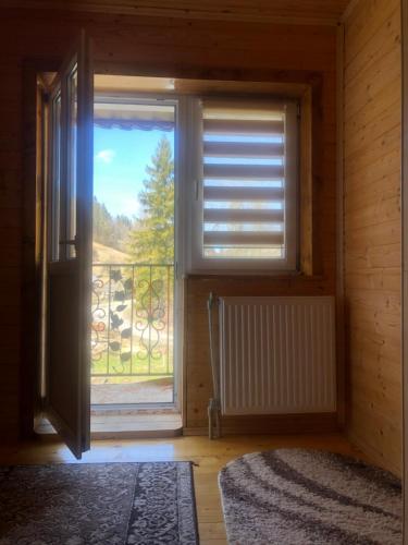 a room with a window with a view of a balcony at Sadyba Domashniy zatyshok in Pilipets