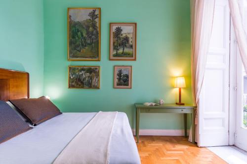ナポリにあるAppartamento a Piazza Cavour by Wonderful Italyの青い壁のベッドルーム(ベッド1台、テーブル付)