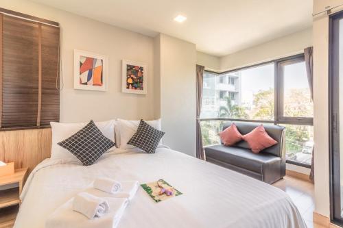 a bedroom with a large bed and a chair at Casa Luxe Hotel and Resident in Bangkok