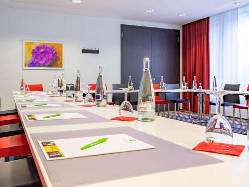 a conference room with a long table with wine bottles at ibis Styles Karlsruhe Ettlingen in Ettlingen
