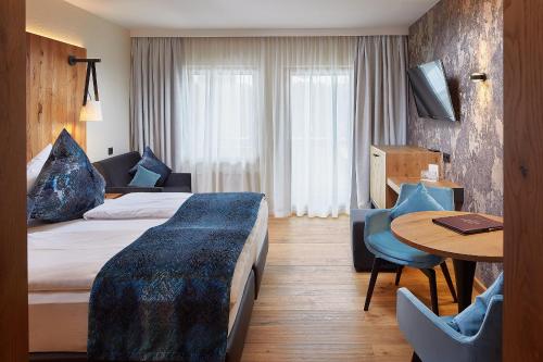 um quarto de hotel com uma cama e uma mesa em Sporthotel Ellmau in Tirol em Ellmau