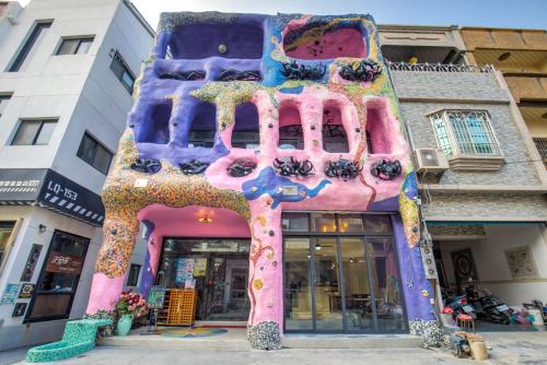 ein Gebäude mit einem Gemälde an der Seite in der Unterkunft Village Hostel in Xiaoliuqiu