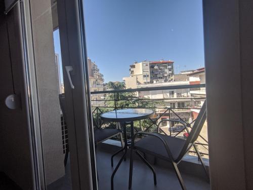 a balcony with a table and a view of a city at Kapsouli Square Komotini in Komotini