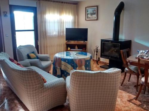 a living room with a table and chairs and a fireplace at Casa La Huerta in Bubión