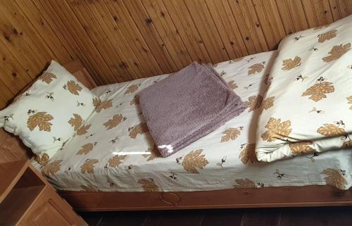 uma cama com um cobertor e almofadas em Camping Lotca Fermecata em Cazasu