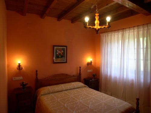 PiloñaにあるTurismo Rural el Sidronのベッドルーム1室(ベッド1台、シャンデリア付)