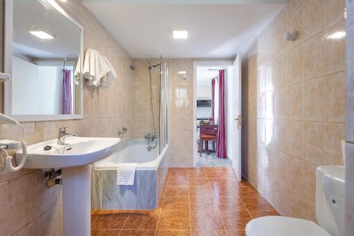 a bathroom with a sink and a bath tub at Apartamentos Cala Murada Tennis in Cala Murada