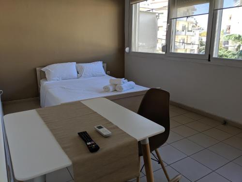 a small room with a bed and a table with a remote control at Kapsouli Square Komotini in Komotini