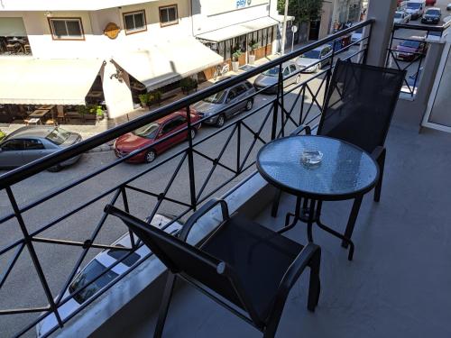 a table and chairs on a balcony with a view of a street at Kapsouli Square Komotini in Komotini