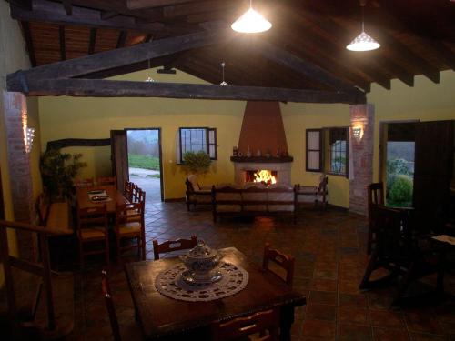 PiloñaにあるTurismo Rural el Sidronのリビングルーム(暖炉、テーブル、椅子付)