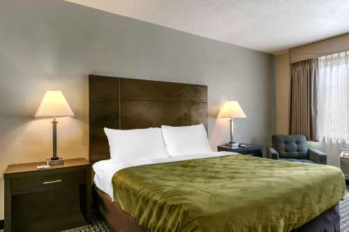 a hotel room with a bed and a chair and lamps at Quality Inn Rawlins I-80 in Rawlins