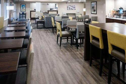 Comfort Inn & Suites Conway في كونوي: غرفة طعام مع طاولات وكراسي في مطعم