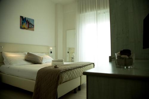 a bedroom with a bed and a chair and a window at San Marco in Marotta