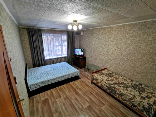 アストラハンにあるАпартаменты у Макдональдсаのベッド2台とテレビが備わる客室です。