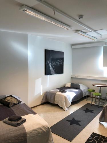 a bedroom with two beds and a table in it at Hostel400Kokkola Tehtaankatu in Kokkola