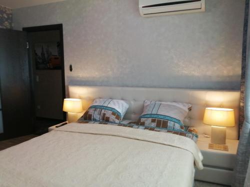 a bedroom with a bed with two pillows and two lamps at Apartment on Lenina 49 in Salihorsk