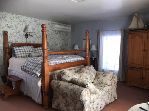 a bedroom with a bed and a couch next to a bed at Fallen Tree Farm Bed and Breakfast in Carlisle