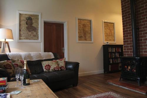 a living room with a couch and a fireplace at wingate cottage in Southburgh