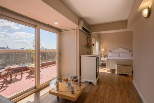 a living room with a bed and a glass table at Exe Hotel Colón in Buenos Aires