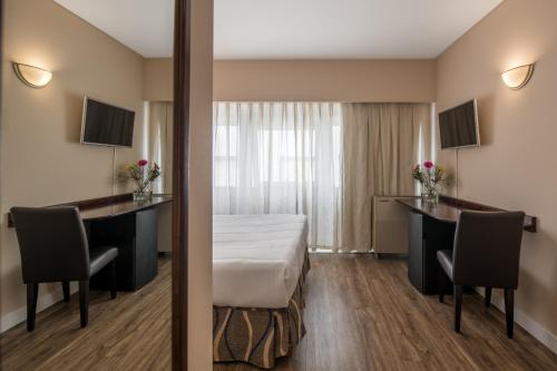 a hotel room with a bed and a desk at Exe Hotel Colón in Buenos Aires