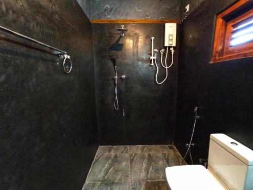 ein Badezimmer mit Dusche und Toilette in der Unterkunft Oasis Safari Cottage in Udawalawe