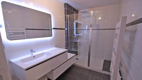 une salle de bain blanche avec un lavabo et une douche dans l'établissement Le Riviera, à Sainte-Maxime