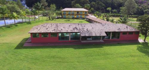 a red house on a green field with a house at Espaço Casa na Rocha in São José dos Campos