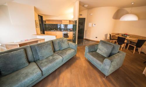 a living room with a couch and two chairs at Appartamenti Pirovano Bormio in Bormio