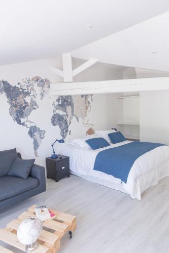 a bedroom with a bed and a map of the world on the wall at Le Mas des Alexandrins in Uzès