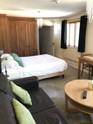 a bedroom with a large bed and a couch at Byways Serviced Apartments in Salisbury