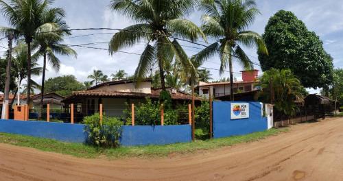 a house on the side of a dirt road with palm trees at Pousada Pôr do Sol in Barra Grande
