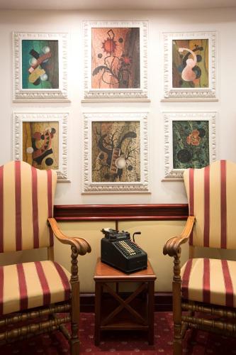 a room with two chairs and a phone on a table at The Britannia Hotel in Rome