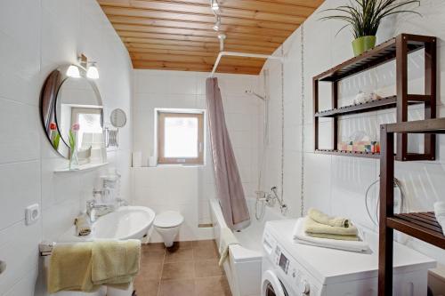ein weißes Bad mit einem Waschbecken und einem WC in der Unterkunft Almrausch Ferienwohnung in Ramsau bei Berchtesgaden