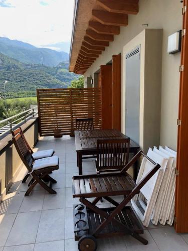 a balcony with wooden chairs and tables and a view at Silver Thermal Home in Arco