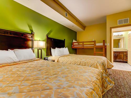 a hotel room with two beds and a green wall at The Resort at Governor's Crossing in Pigeon Forge