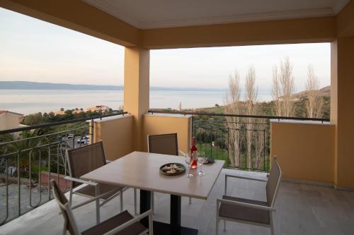 a table and chairs on a balcony with a view of the ocean at Sunrise Resort Hotel in Mithymna