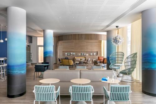 a lobby with blue and white chairs and tables at OKKO Hotels Toulon Centre in Toulon