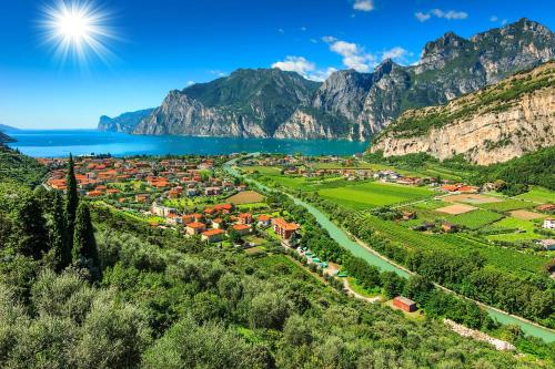 a village on a hill next to a lake and mountains at Silver Thermal Home in Arco