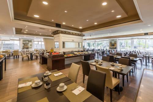 a restaurant with tables and chairs and a buffet at Exe Hotel Colón in Buenos Aires