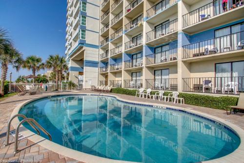 a swimming pool in front of a apartment building at Spectacular Ocean View Condo at Carolinian Beach Resort in Myrtle Beach