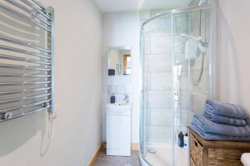 a bathroom with a shower with blue towels on a table at Bristol Little House in Bristol