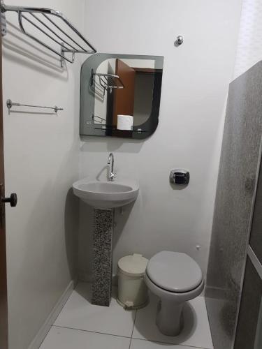 a bathroom with a sink and a toilet and a mirror at PEDRA BONITA PRECIOSO HOTEL ltda in Itaboraí
