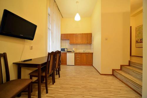 a kitchen with a table and chairs and a television at Apartaments Piotrkowska 101 in Łódź